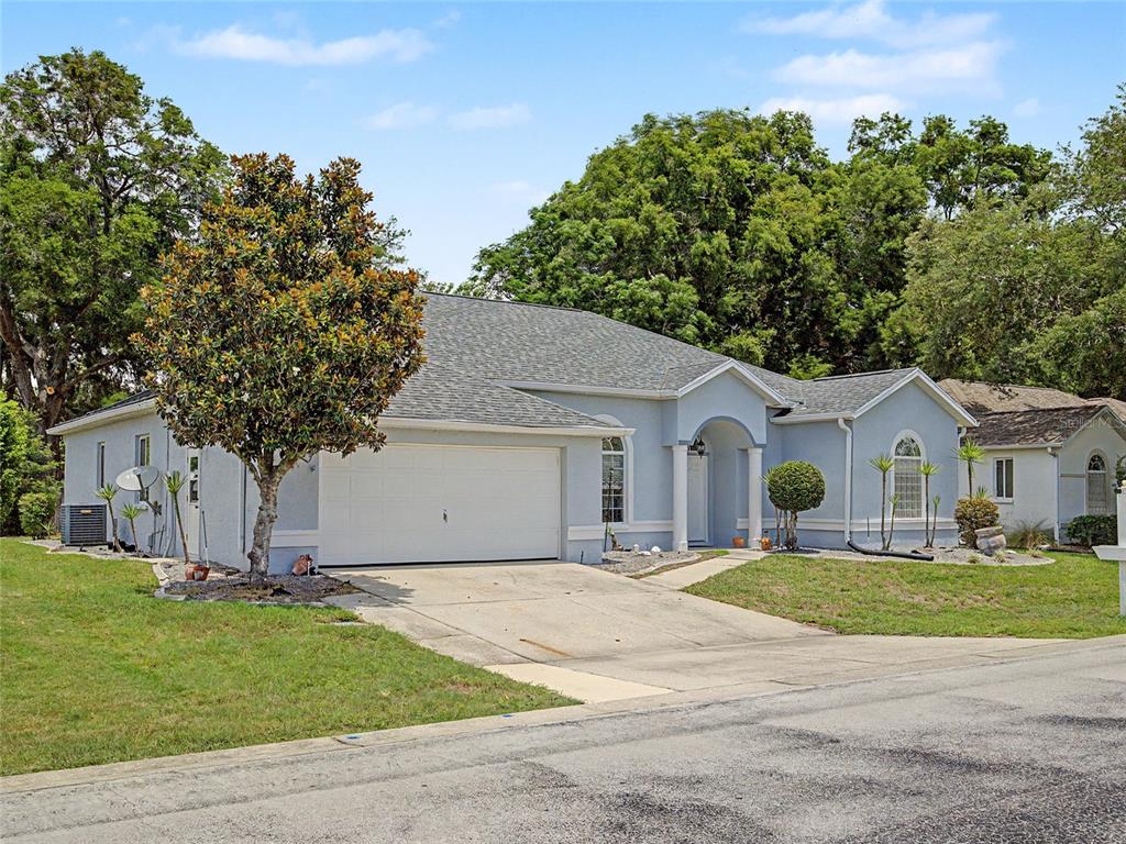 A light blue single-story house with a two-car garage and a paved driveway — 5455 NW 26TH LANE, OCALA, FL