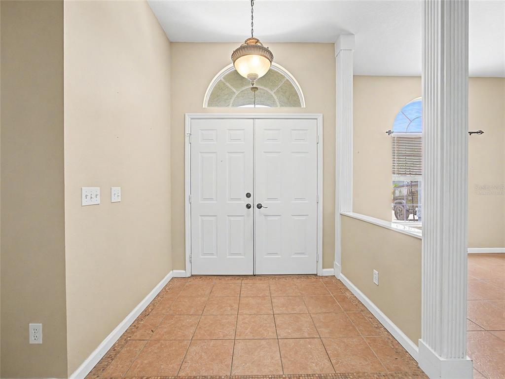 An entryway features a double front door, a tile floor, and a hanging light fixture — 5455 NW 26TH LANE, OCALA, FL