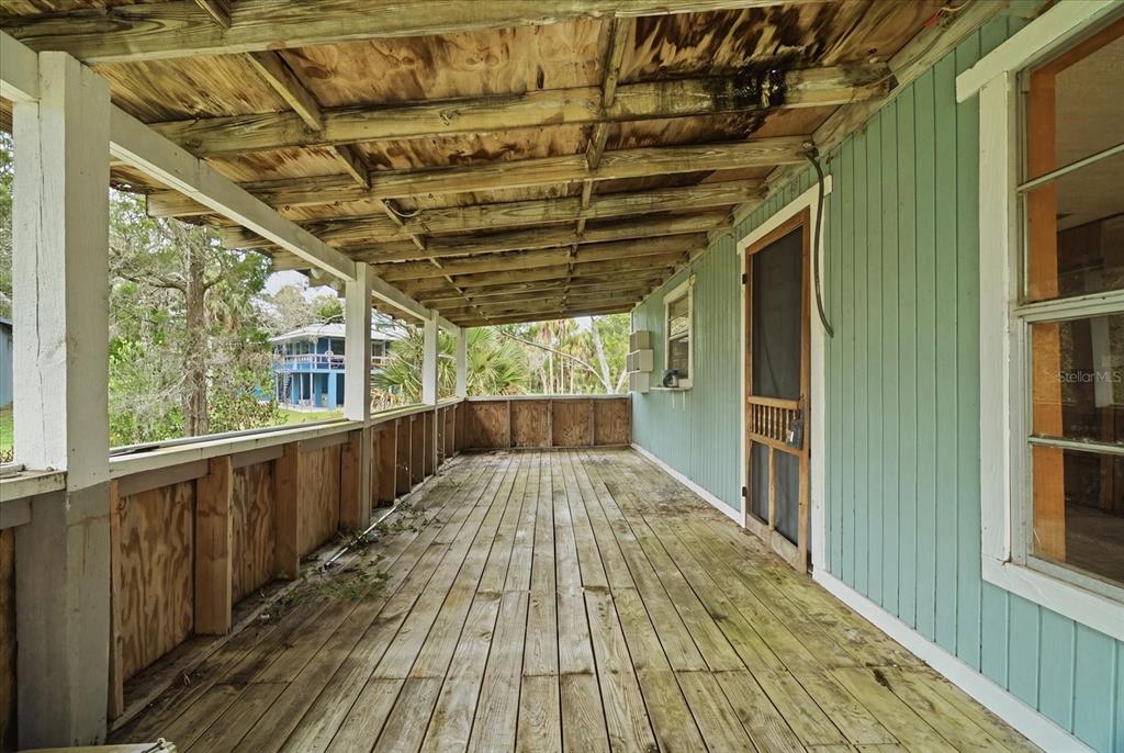 A weathered wooden porch with a plywood ceiling and a teal-sided exterior wall — 14496 & 14498 W CAPTAIN COURT, CRYSTAL RIVER, FL