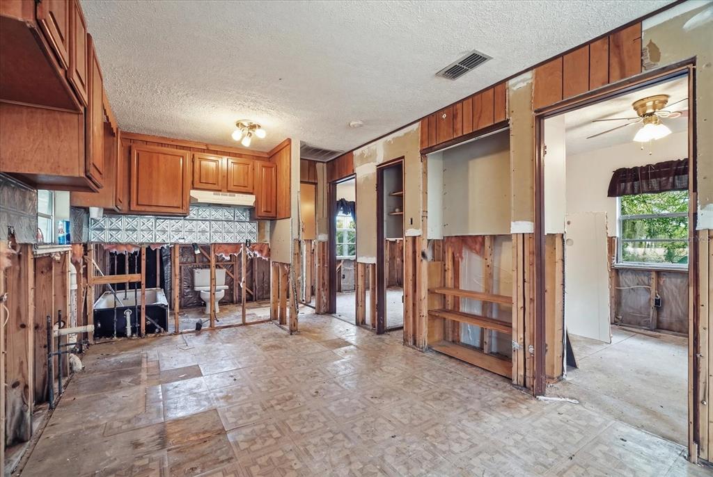 An interior view of a room under renovation with exposed wall studs and wood cabinets — 14496 & 14498 W CAPTAIN COURT, CRYSTAL RIVER, FL