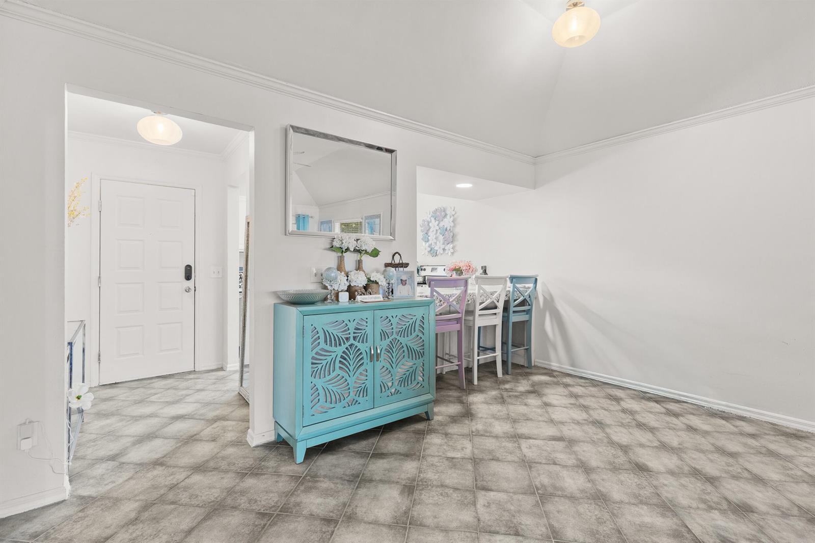 A dining area features a turquoise cabinet, tiled floors, and three colorful bar stools — 1329 Villa Lane # 45, FL 32712, FL