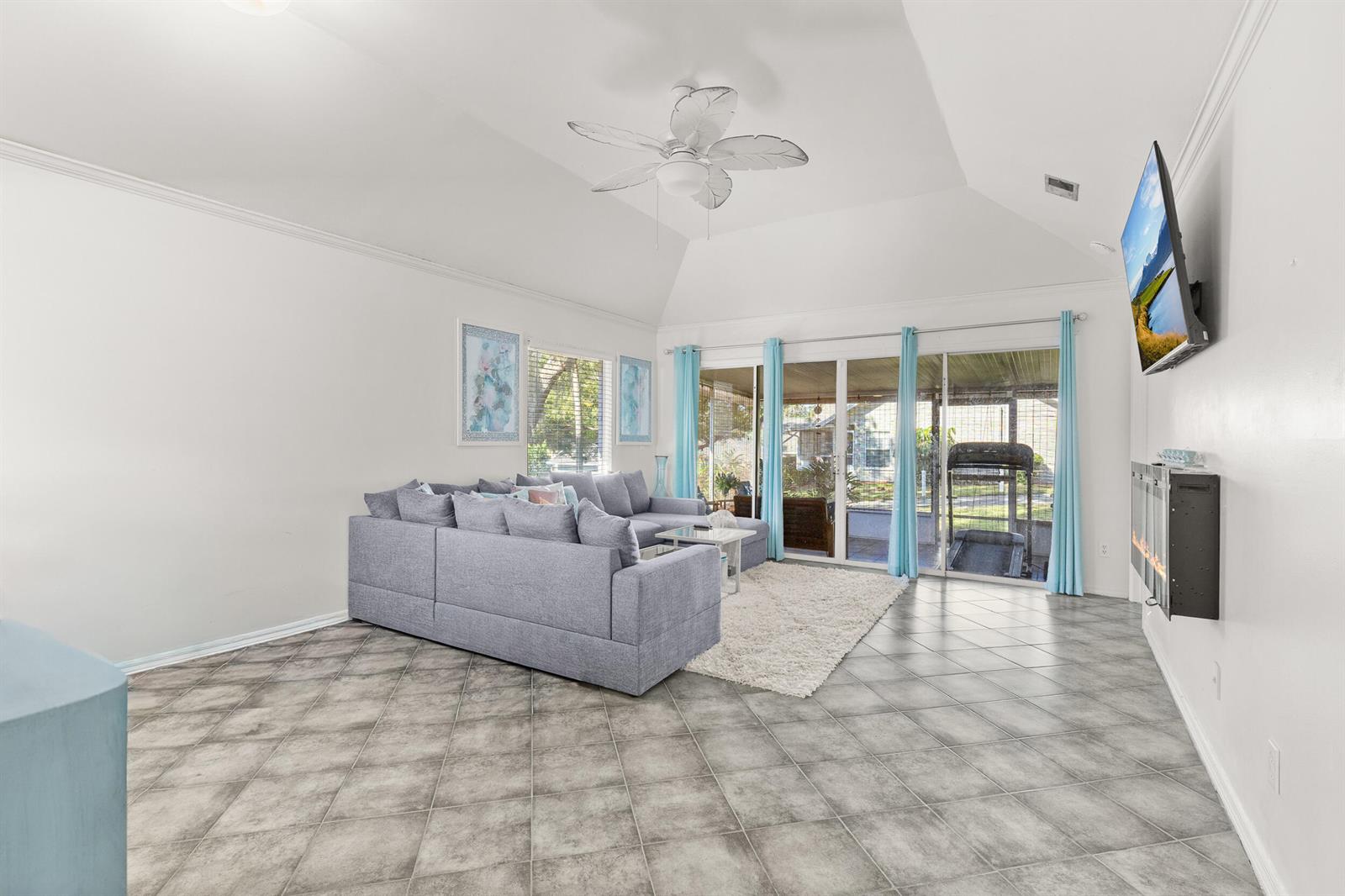 A living room features a grey sectional sofa, tiled floors, a vaulted ceiling, and a fireplace — 1329 Villa Lane # 45, FL 32712, FL
