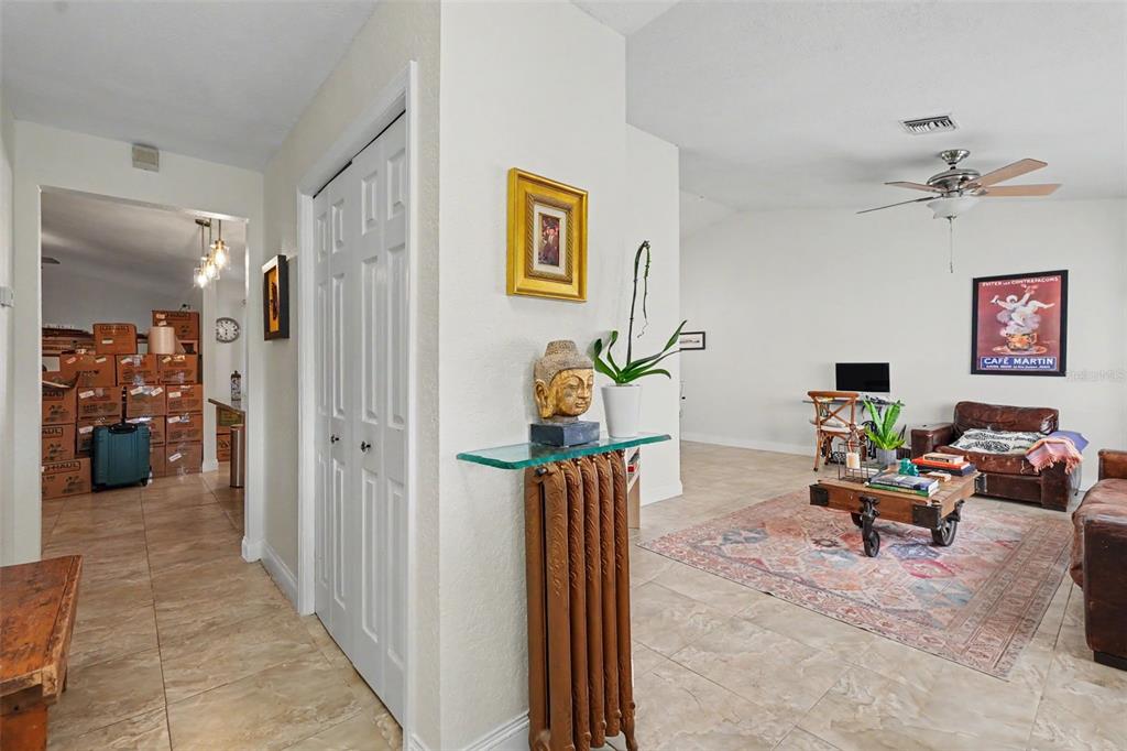 A living room with tile floors, a glass-topped radiator console, and a brown leather sofa — 12543 108TH STREET, LARGO, FL
