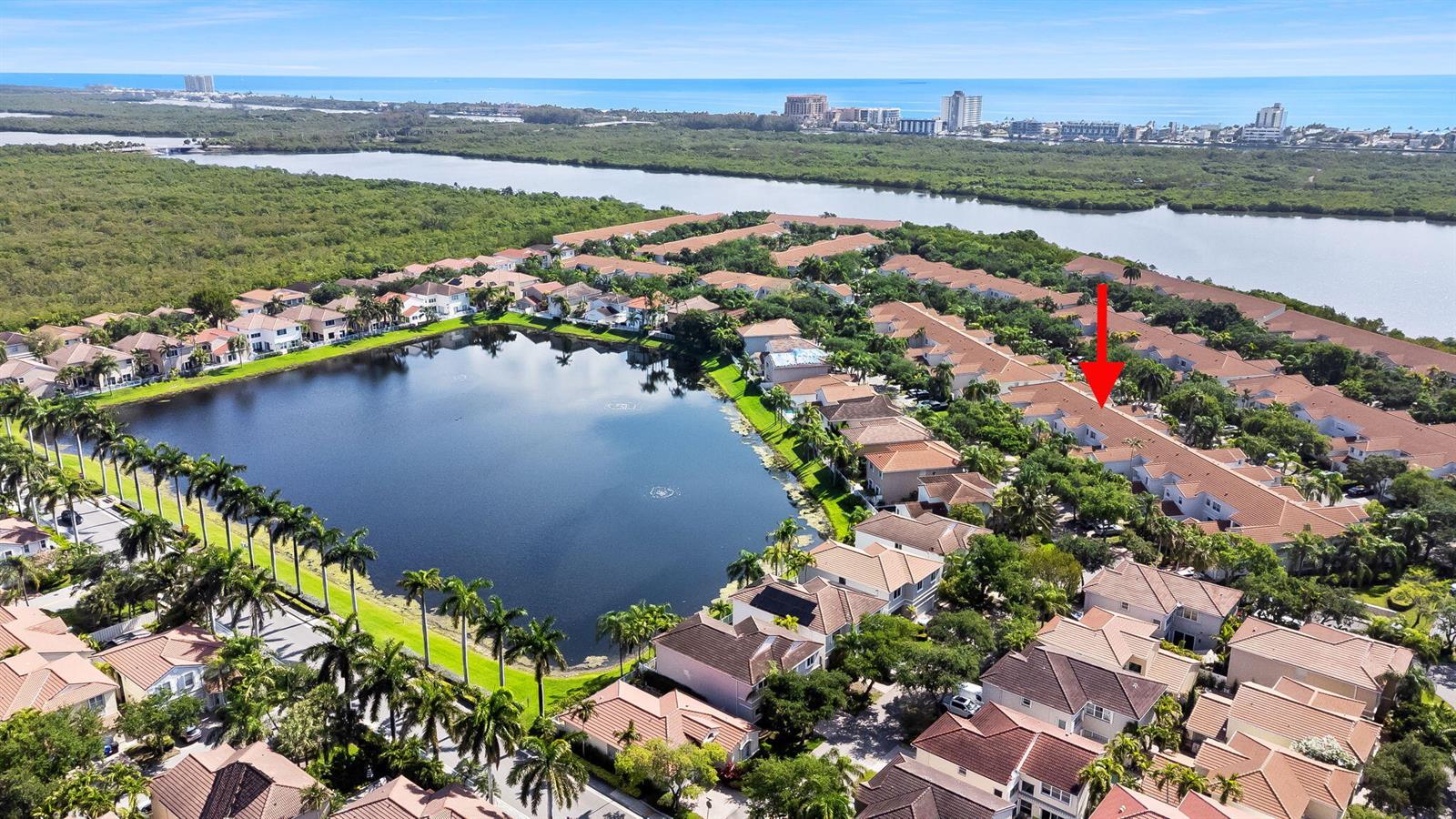 An aerial view shows a residential community with a large lake and red-tiled roofs — 1551 Seagrape Way, Hollywood FL 33019, HOLLYWOOD, FL