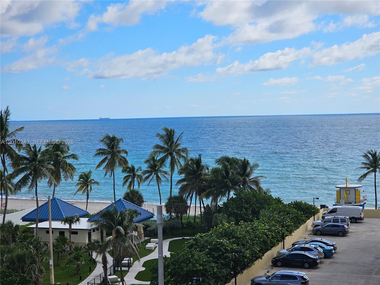 An elevated view of a beach, palm trees, a lifeguard tower, and a parking lot — 2501 S OCEAN DR # 637, Hollywood FL 33019, HOLLYWOOD, FL