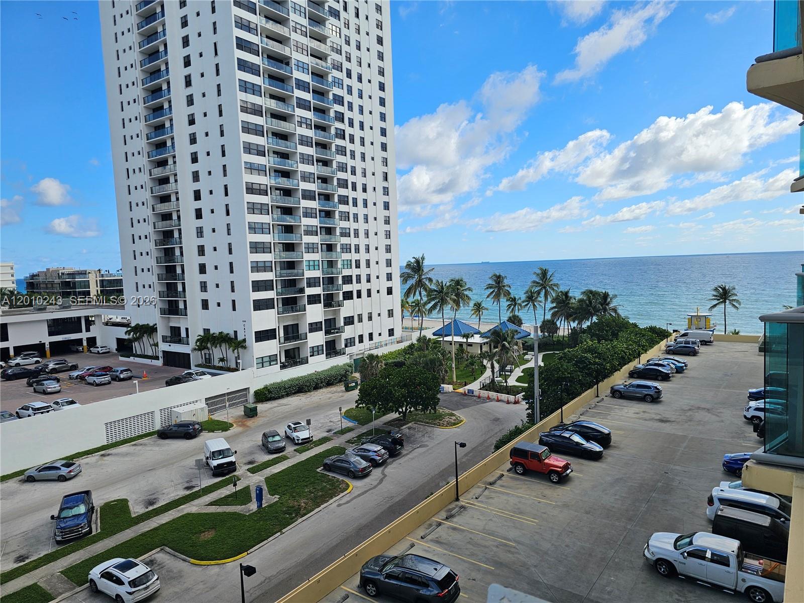 An elevated view shows a tall white apartment building next to a parking lot and beach — 2501 S OCEAN DR # 637, Hollywood FL 33019, HOLLYWOOD, FL
