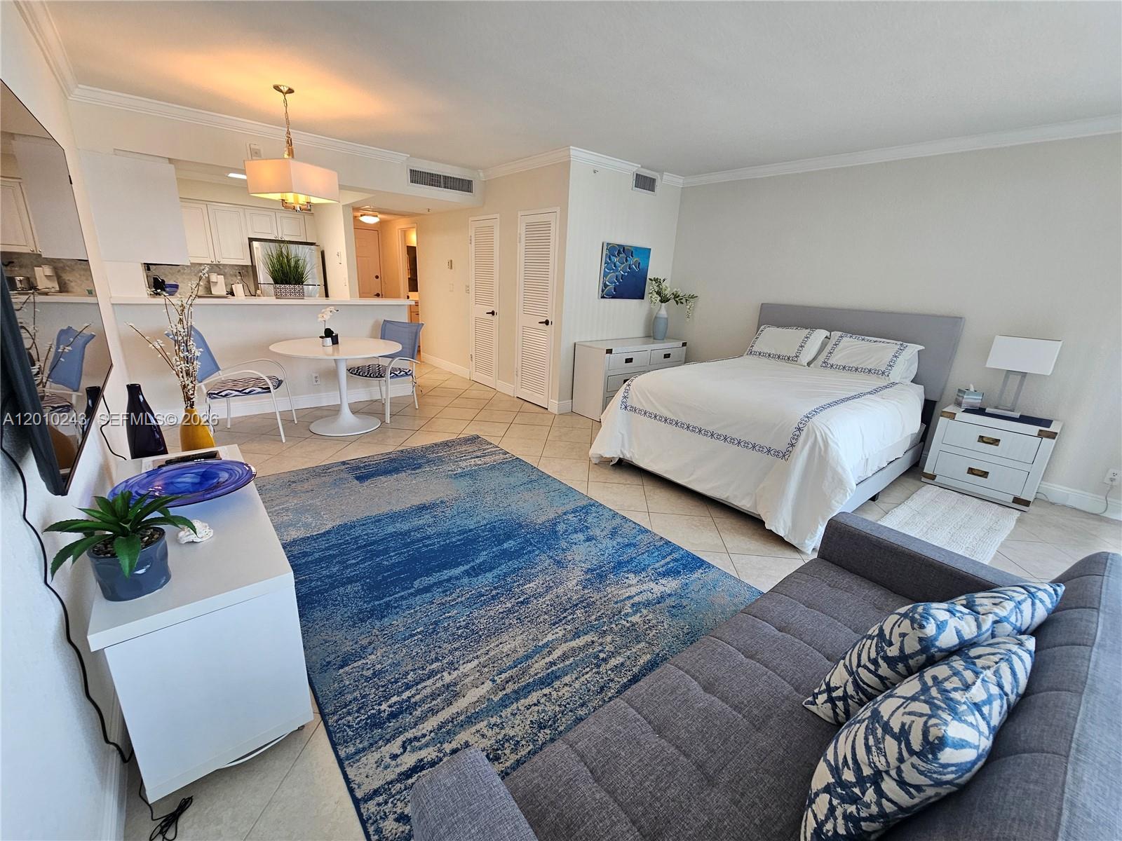 A studio apartment features a bed, a small dining area, and a blue area rug — 2501 S OCEAN DR # 637, Hollywood FL 33019, HOLLYWOOD, FL