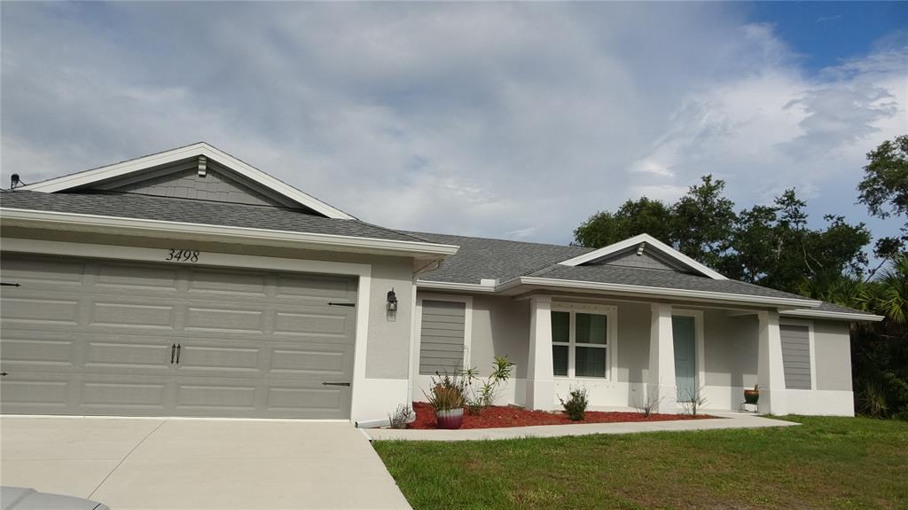 A single-story house with a gray garage, light-colored stucco walls, and a shingled roof — 3498 GARBETT TERRACE, NORTH PORT, FL