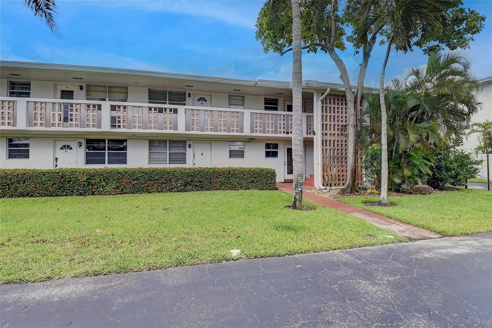 A two-story apartment building with a balcony, a hedge, and a paved walkway — 30 SE 13th Street # B2, Boca Raton FL 33432, BOCA RATON, FL