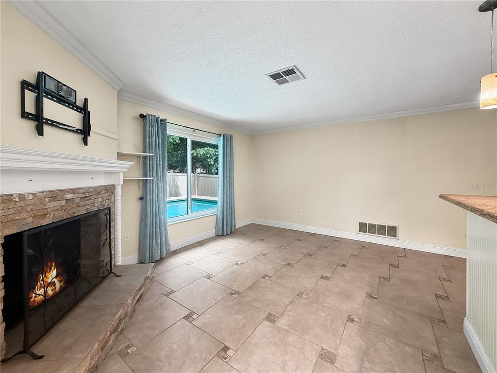 The exterior of a house features a red front door, a large window, and landscaping — 1011 WINDING OAKS DRIVE, PALM HARBOR, FL