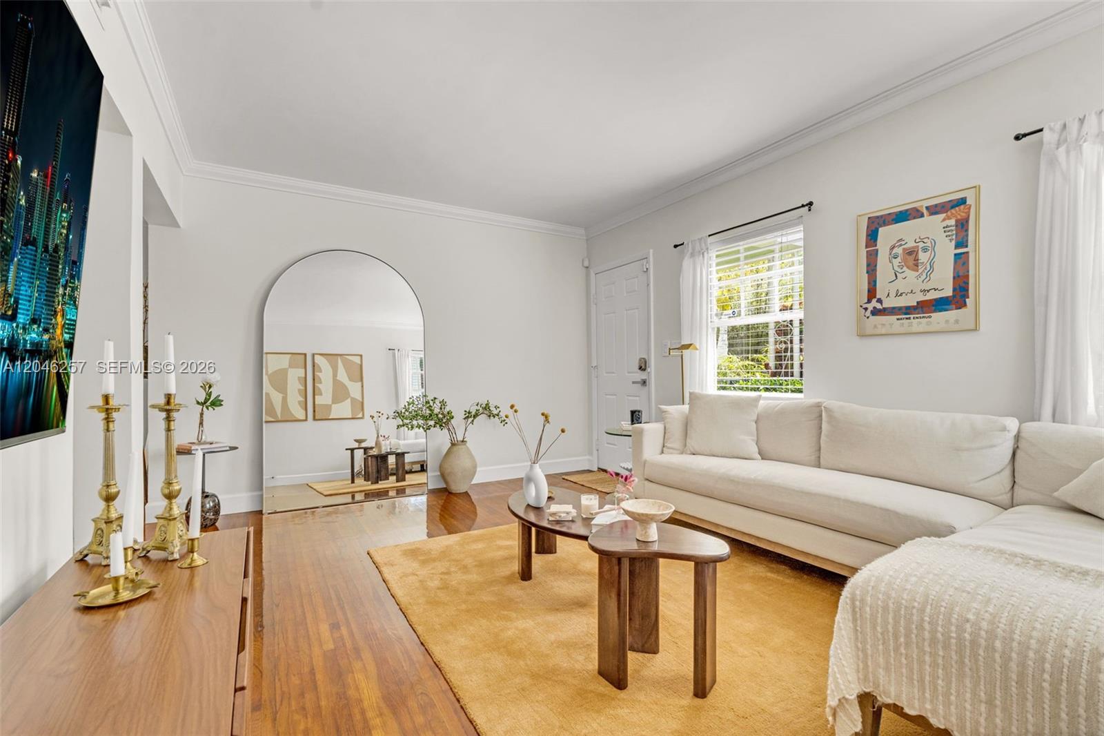 A living room features a white sectional sofa, a mustard rug, and an arched floor mirror — 915 8th St # 101, Miami Beach FL 33139, MIAMI BEACH, FL