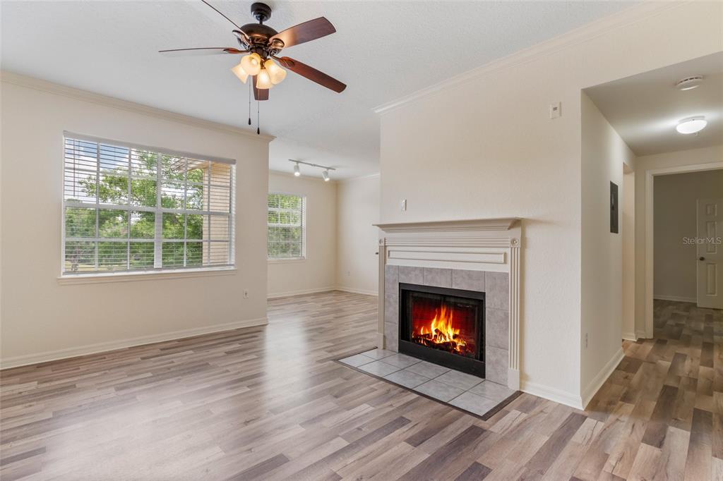 A living room features light wood-look flooring, a fireplace with tile surround, and a ceiling fan — 2558 ROBERT TRENT JONES DRIVE UNIT 1434, ORLANDO, FL