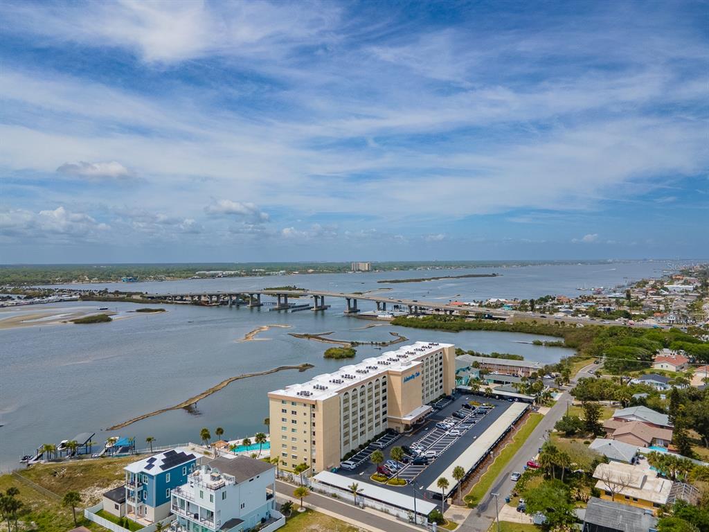 An aerial view shows a multi-story hotel building near a bridge over a large bay — 3606 S PENINSULA DRIVE UNIT 605, PORT ORANGE, FL