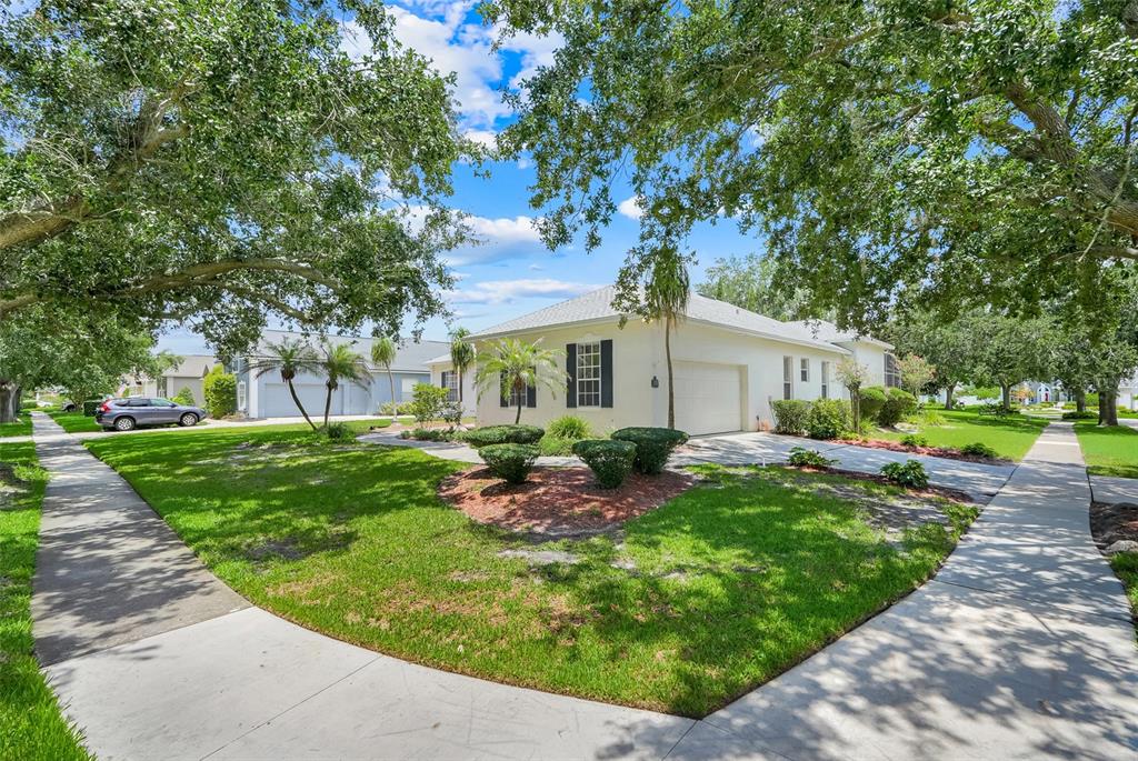 A single-story house with a white exterior, a two-car garage, and a landscaped front yard — 8003 BELSHIRE DRIVE, ORLANDO, FL