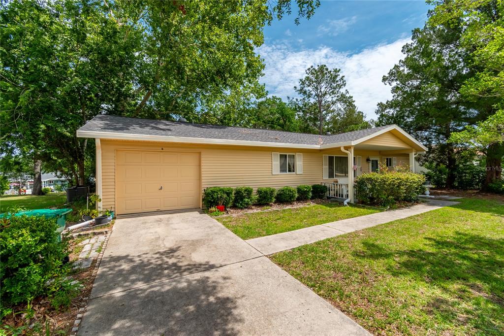 A single-story house with light yellow siding, a one-car garage, and a concrete driveway — 8173 SW 107TH PLACE, OCALA, FL