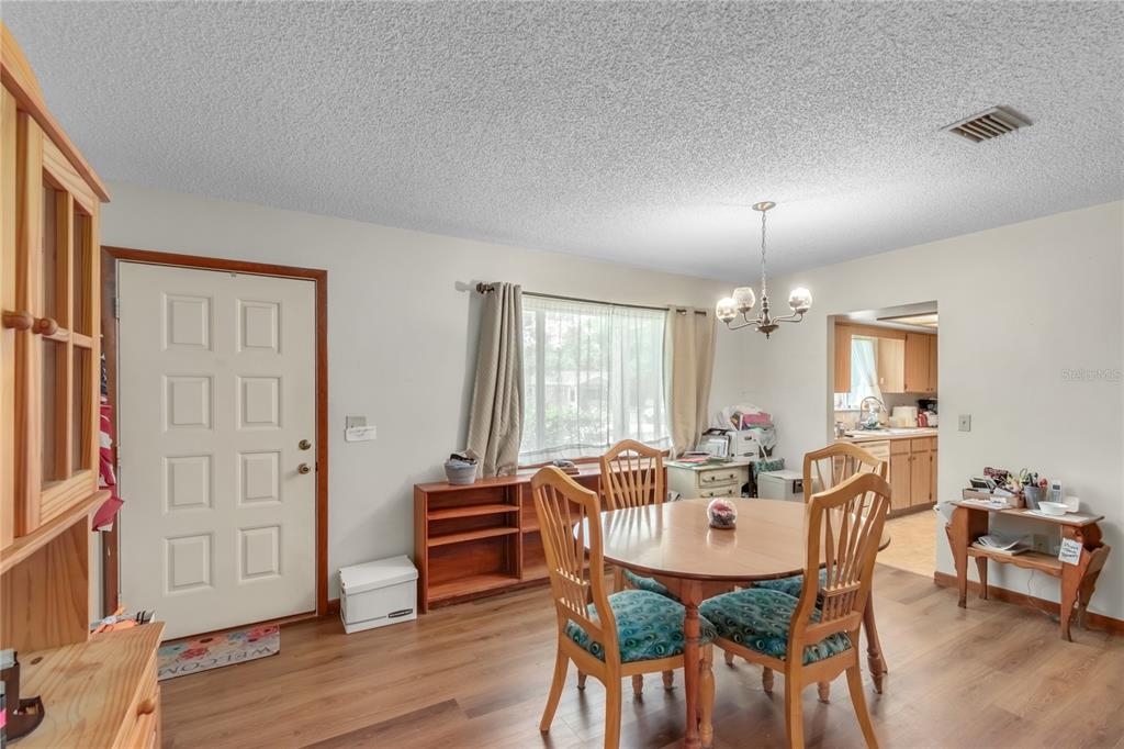 A dining area features a round wooden table, four chairs, and a white front door — 8173 SW 107TH PLACE, OCALA, FL