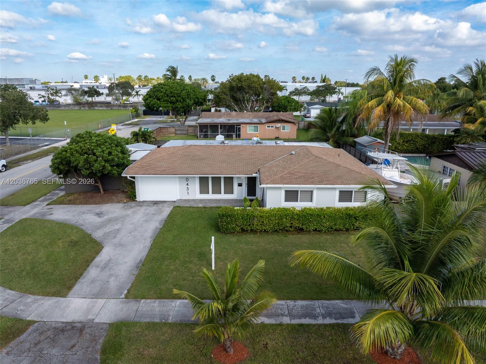 An aerial view shows a single-story house with a brown roof, white exterior, and driveway — 10431 SW 93rd St, Miami FL 33176, MIAMI, FL