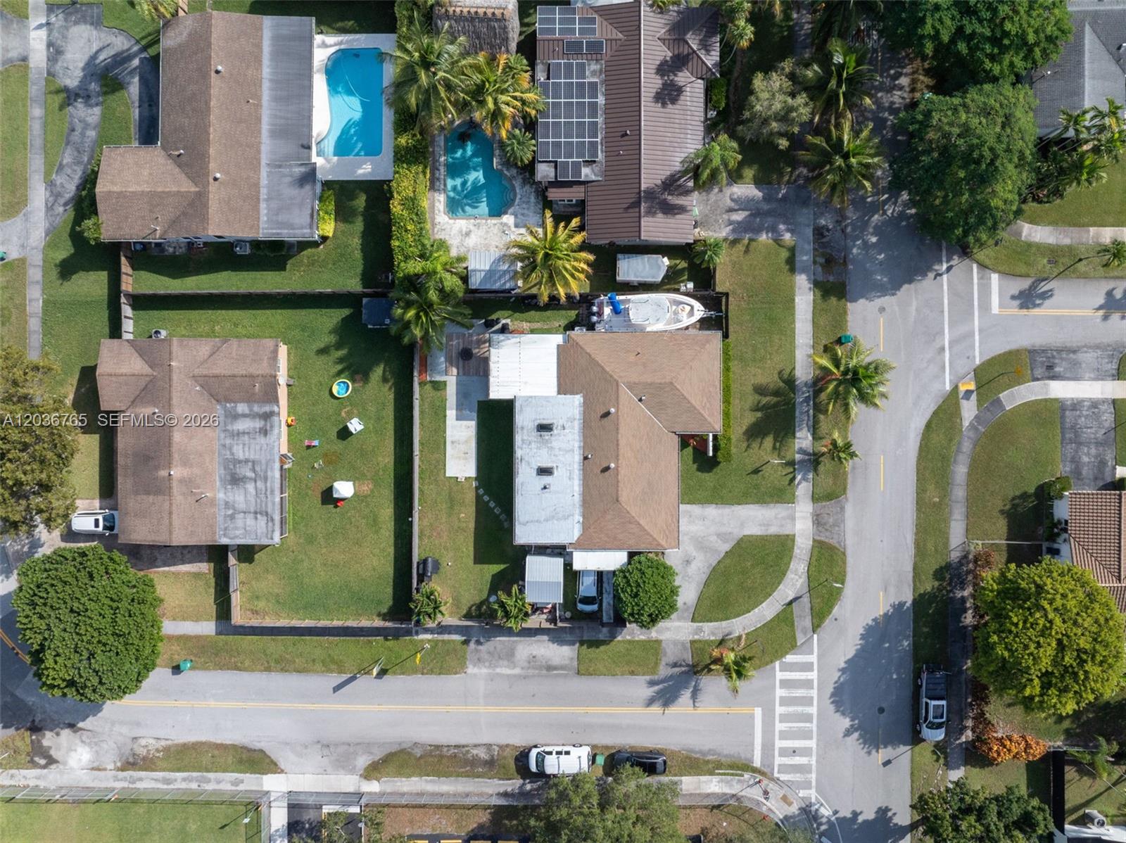 An aerial view shows residential houses with swimming pools, solar panels, and parked vehicles — 10431 SW 93rd St, Miami FL 33176, MIAMI, FL