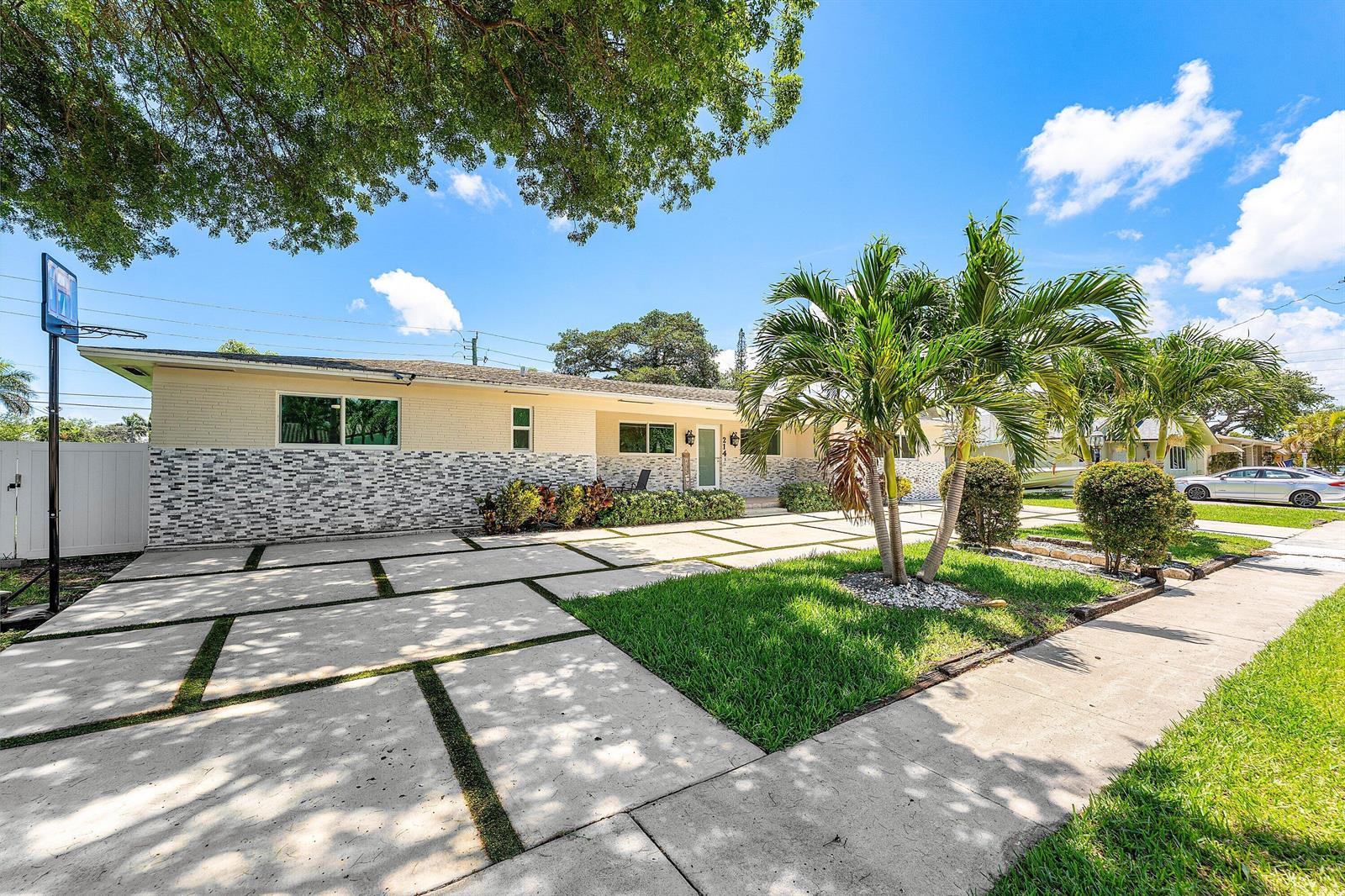 A single-story house with a paved driveway, palm trees, and a basketball hoop — 214 SE 5th Street, Dania Beach FL 33004, DANIA BEACH, FL