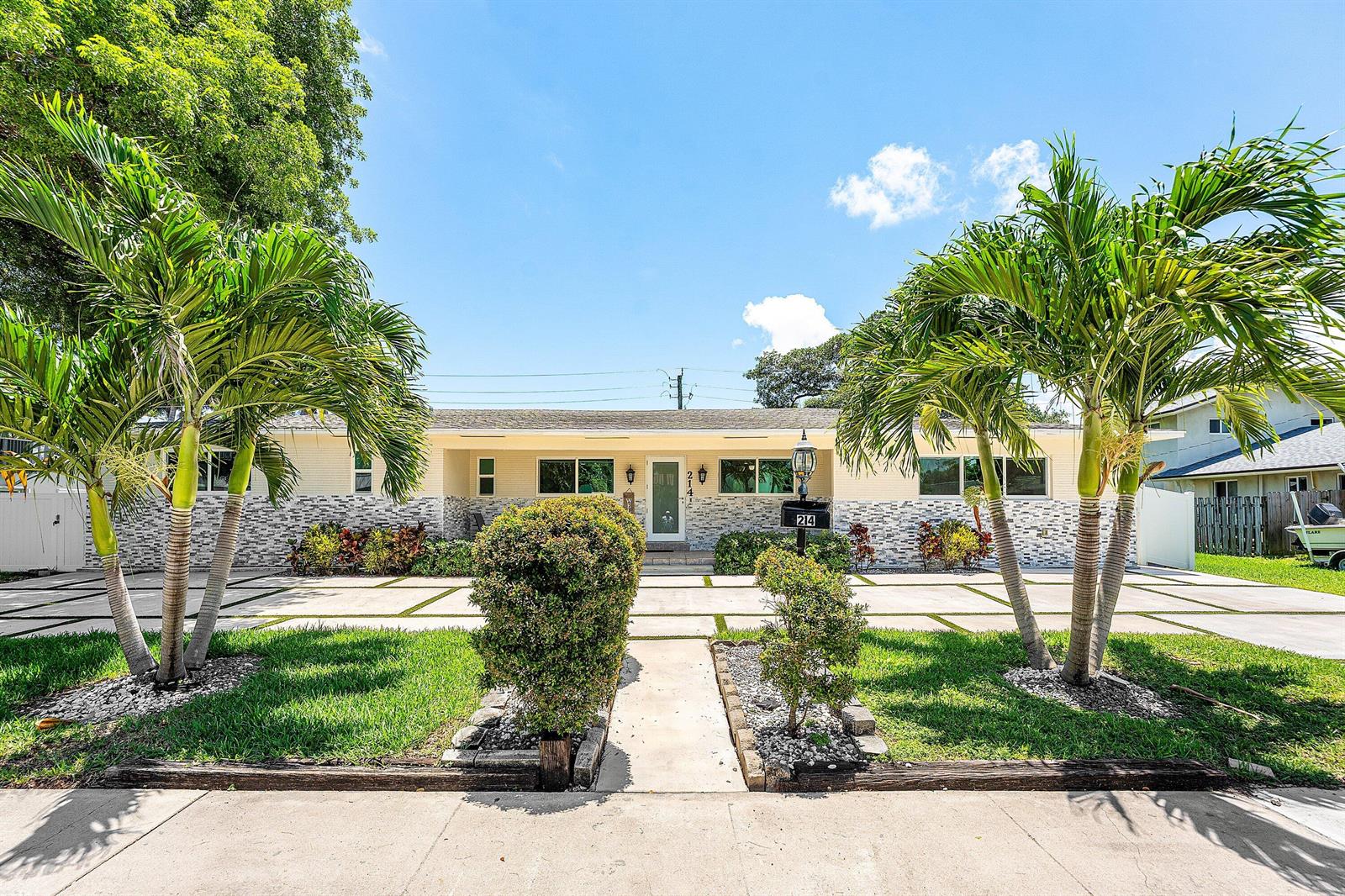 A single-story house with a stone-accented facade, palm trees, and a concrete driveway — 214 SE 5th Street, Dania Beach FL 33004, DANIA BEACH, FL