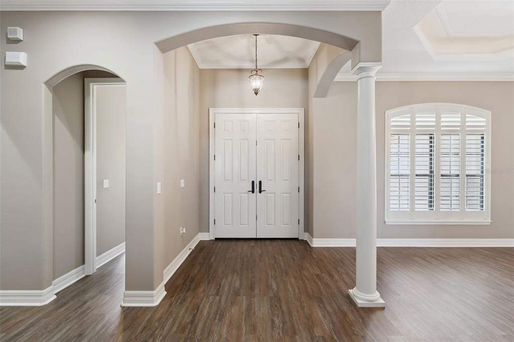 An entryway features wood-look flooring, a white double door, an arched opening, and a column — 19850 SUGARLOAF MOUNTAIN ROAD, CLERMONT, FL