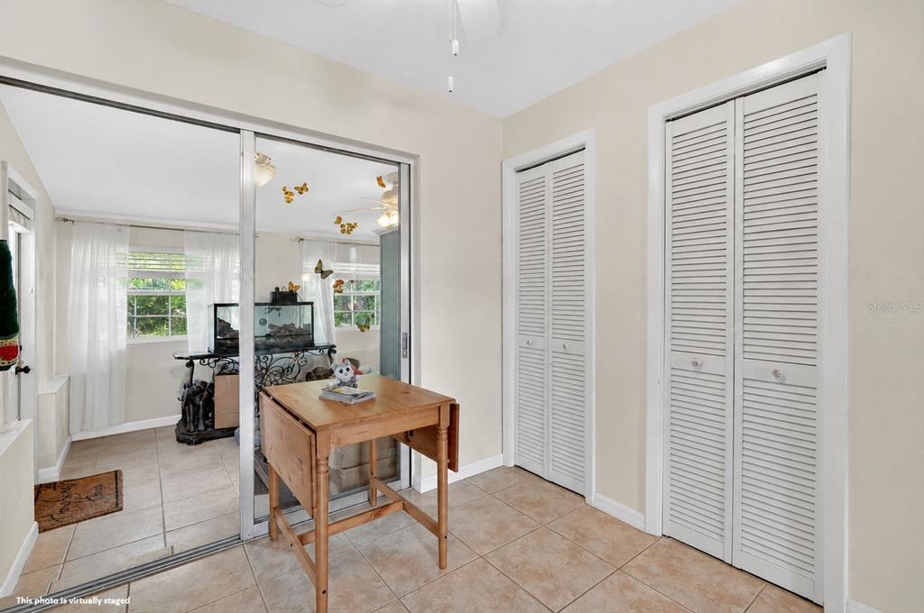 A room with tiled floors, two louvered closet doors, and a sliding glass door partition — 1500 PRIMROSE LANE, DAYTONA BEACH, FL