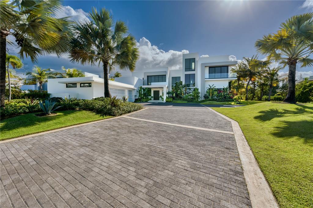 A modern white two-story house with a paved driveway and palm trees in the yard — G8 ATLANTIC DRIVE, 7000 BAHIA BEACH BLVD., RIO GRANDE, PR
