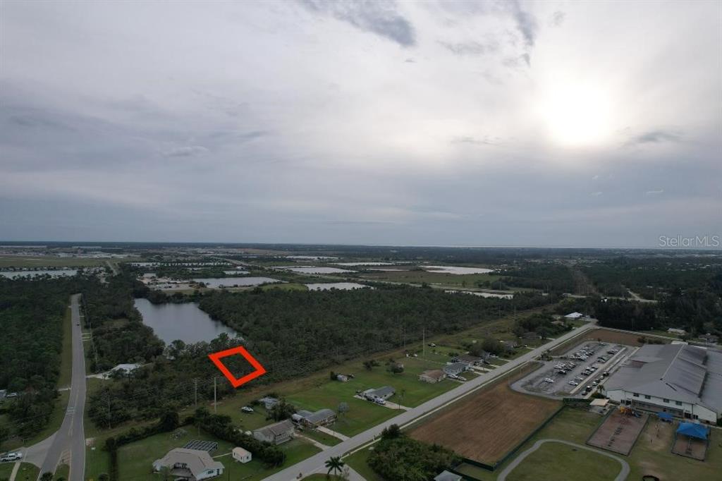 An aerial view shows a vacant lot outlined in red next to a small lake — 4515 S FAIRWAY DRIVE, PUNTA GORDA, FL