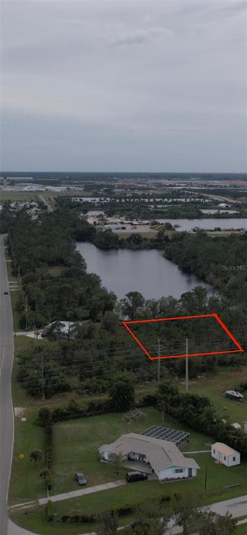 An aerial view shows a rectangular plot of land outlined in red near a lake — 4515 S FAIRWAY DRIVE, PUNTA GORDA, FL