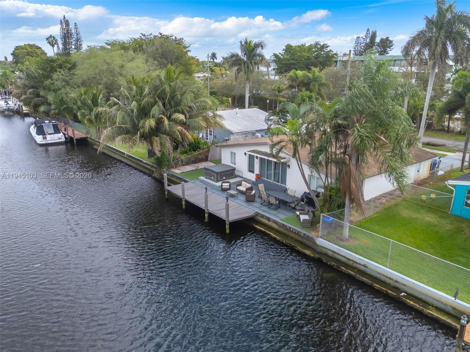 An aerial view shows a waterfront house with a wooden dock, patio, and hot tub — 2721 Harding St, Hollywood FL 33020, HOLLYWOOD, FL