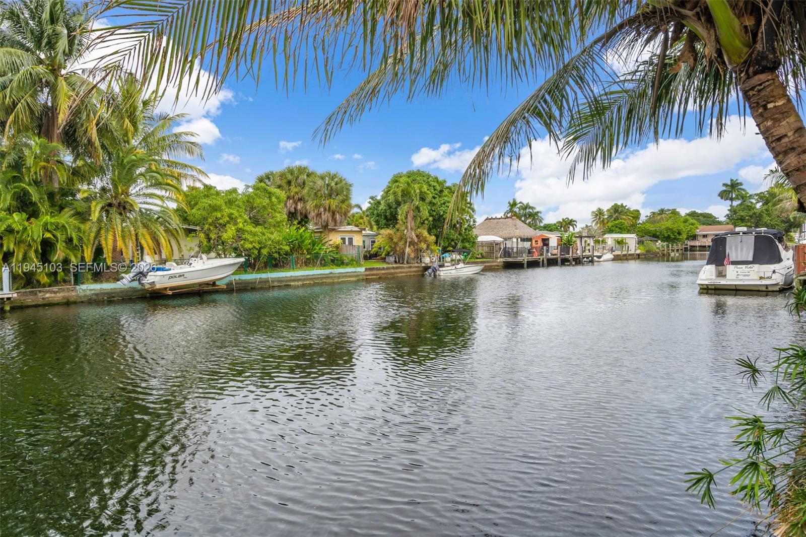 A canal view showing several boats docked along the grassy banks near residential properties — 2721 Harding St, Hollywood FL 33020, HOLLYWOOD, FL