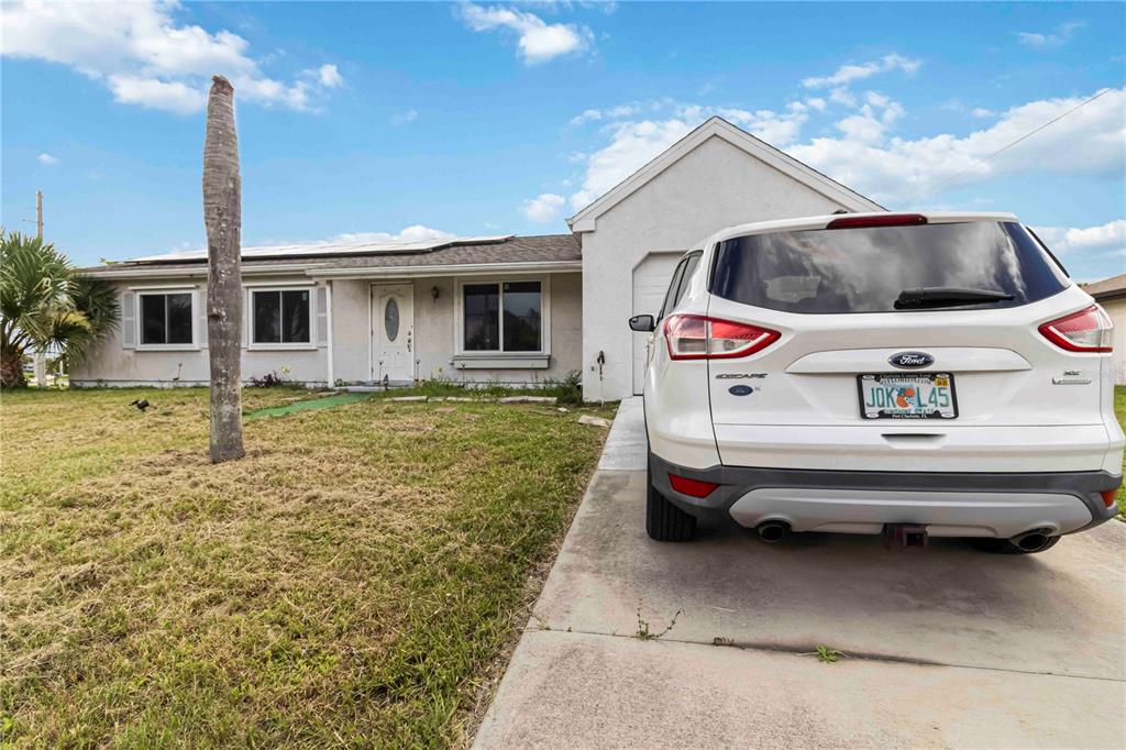 A white single-story house with a driveway and a parked white SUV in front — 20550 EDGEWATER DRIVE, PORT CHARLOTTE, FL