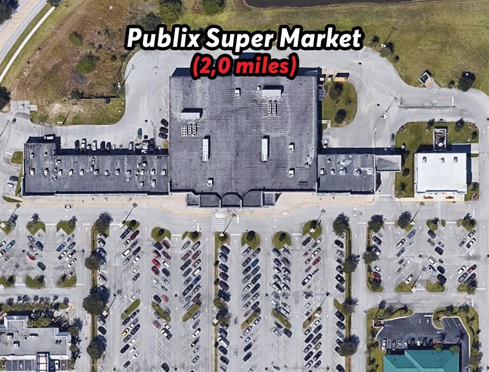 This aerial view shows a commercial shopping center building with a large parking lot — 342 DADEVILLE STREET SE, PALM BAY, FL