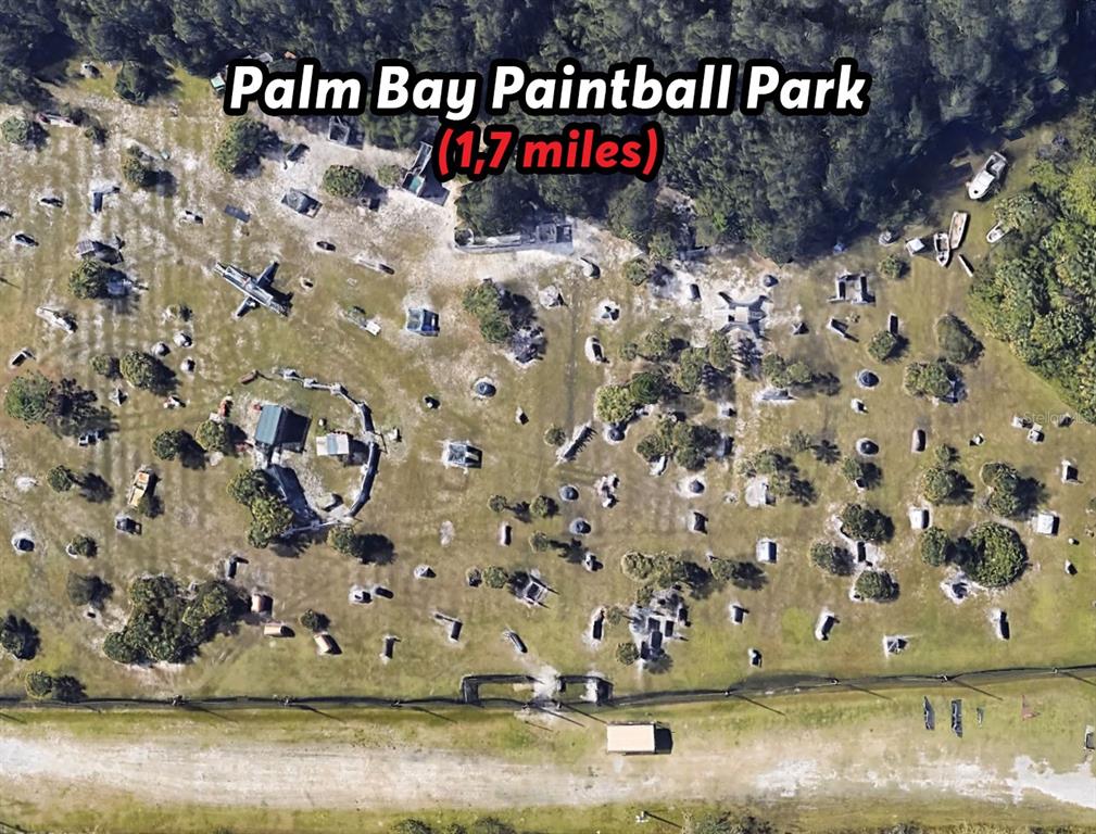 This aerial view shows an outdoor paintball park with various obstacles and structures — 342 DADEVILLE STREET SE, PALM BAY, FL