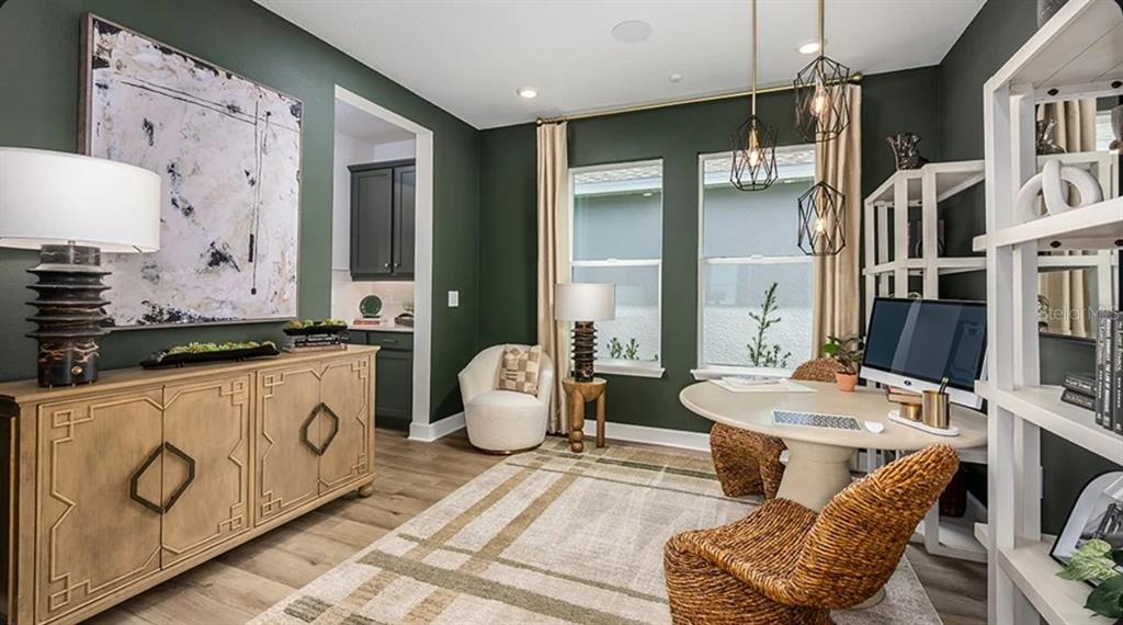 A home office features dark green walls, a light wood sideboard, and a round desk — 5790 BINNACLE LANE, COCOA, FL
