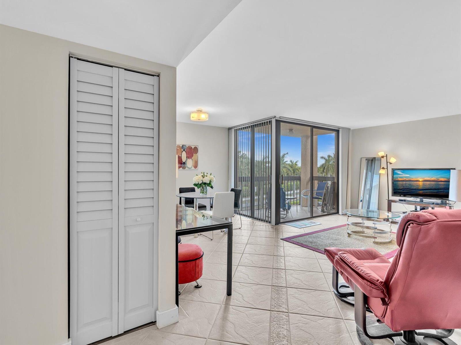 A living and dining area features tile flooring, a glass-topped table, and a balcony view — 2455 Lindell Boulevard # 3401, Delray Beach FL 33444, DELRAY BEACH, FL