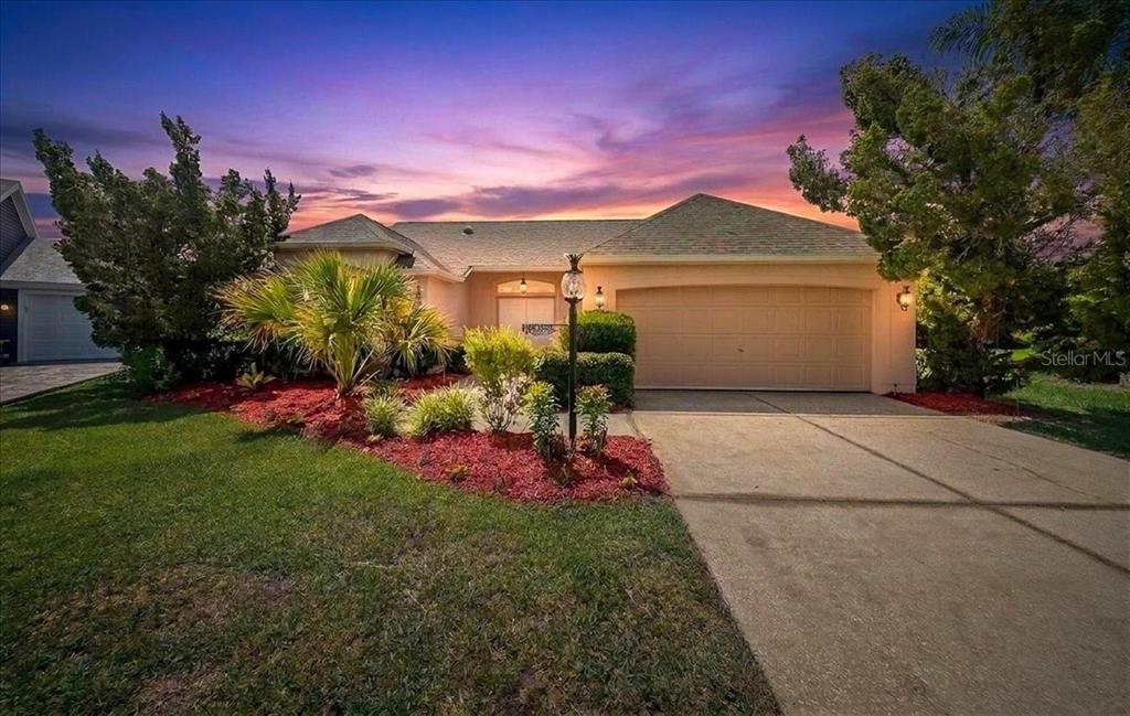 A screened-in patio features a swimming pool with a spillover spa and paver decking — 1302 LOPEZ LANE, THE VILLAGES, FL