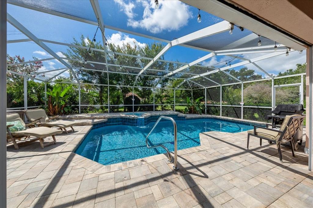A single-story house with a beige exterior, a two-car garage, and a landscaped front yard — 1302 LOPEZ LANE, THE VILLAGES, FL