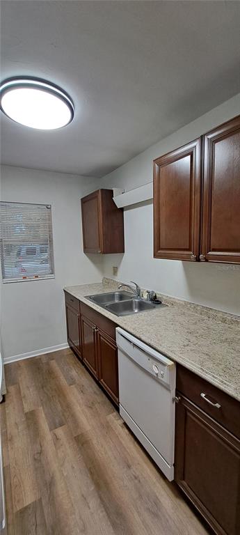 A kitchen features dark wood cabinets, a light speckled countertop, a dishwasher, and wood-look flooring — 3925 SW 26TH TERRACE UNIT B, GAINESVILLE, FL