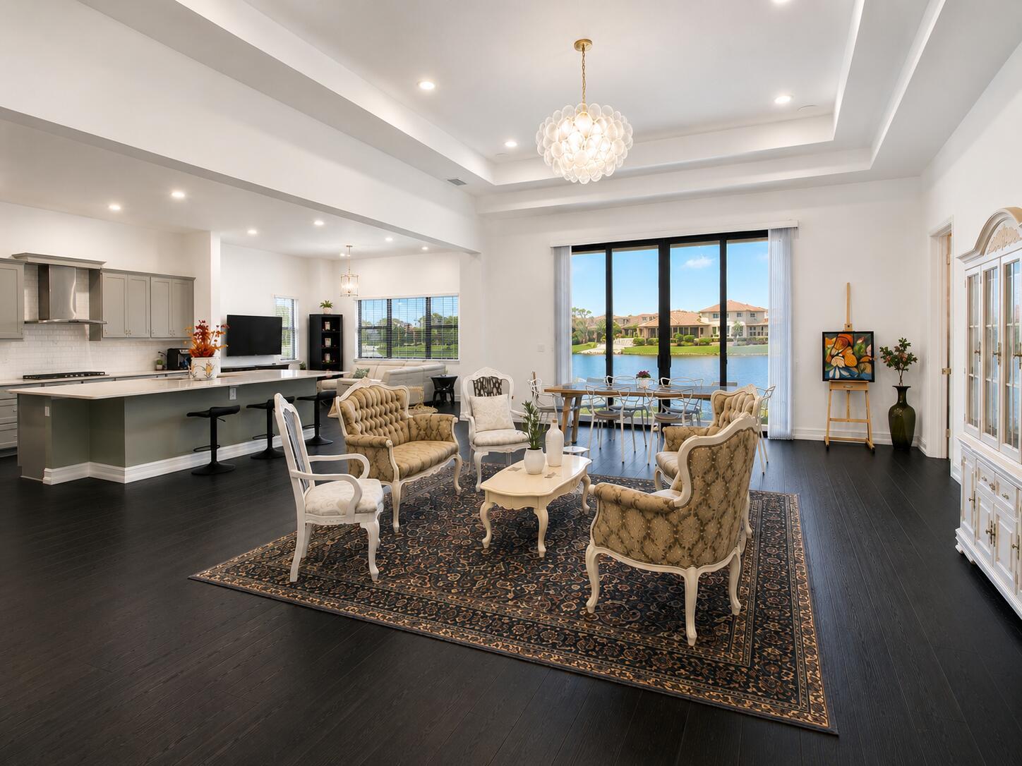 An open-concept living and dining area with dark wood floors, a kitchen, and lake views — 8212 Grand Prix Lane, Boynton Beach FL 33472, BOYNTON BEACH, FL