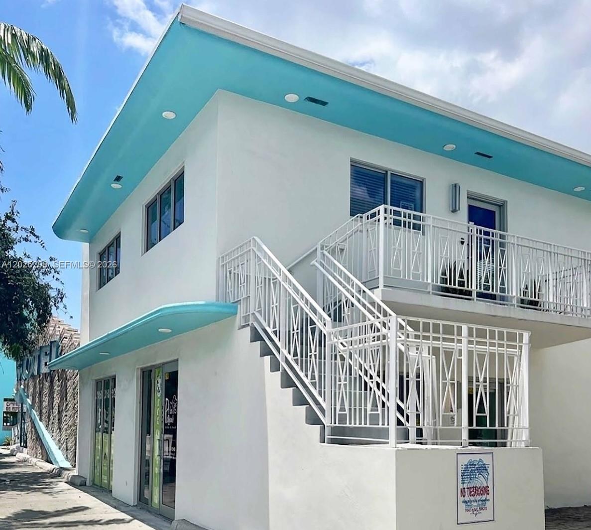 A two-story white building with a bright blue roof overhang and an exterior metal staircase — 6320 Biscayne Blvd, Miami FL 33138, MIAMI, FL