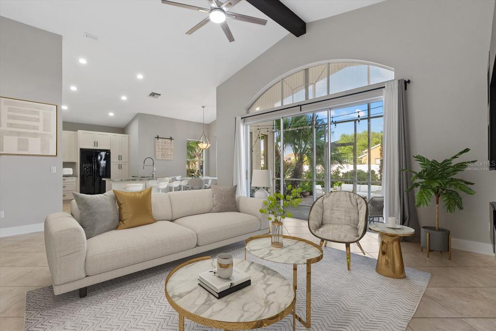 A living room with a sofa, coffee tables, and large sliding doors leading to a patio — 6634 38TH STREET E, SARASOTA, FL