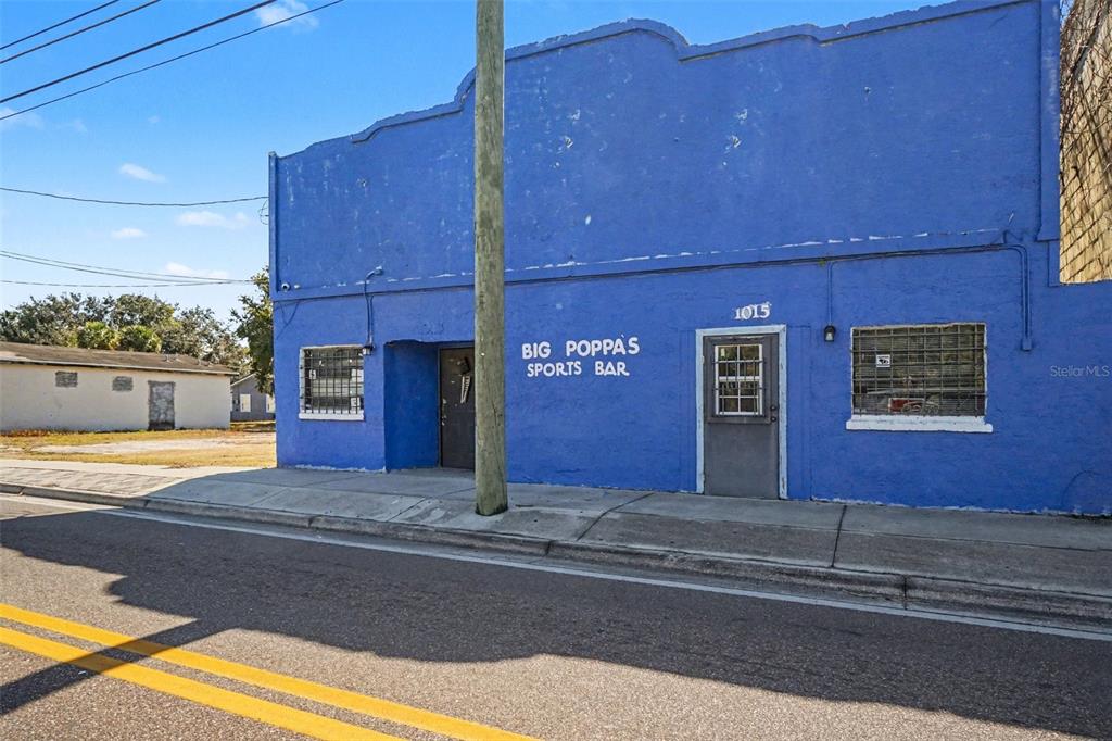 A bright blue commercial building with a sports bar sign stands along a paved road — 1013 HISTORIC GOLDSBORO BOULEVARD, SANFORD, FL