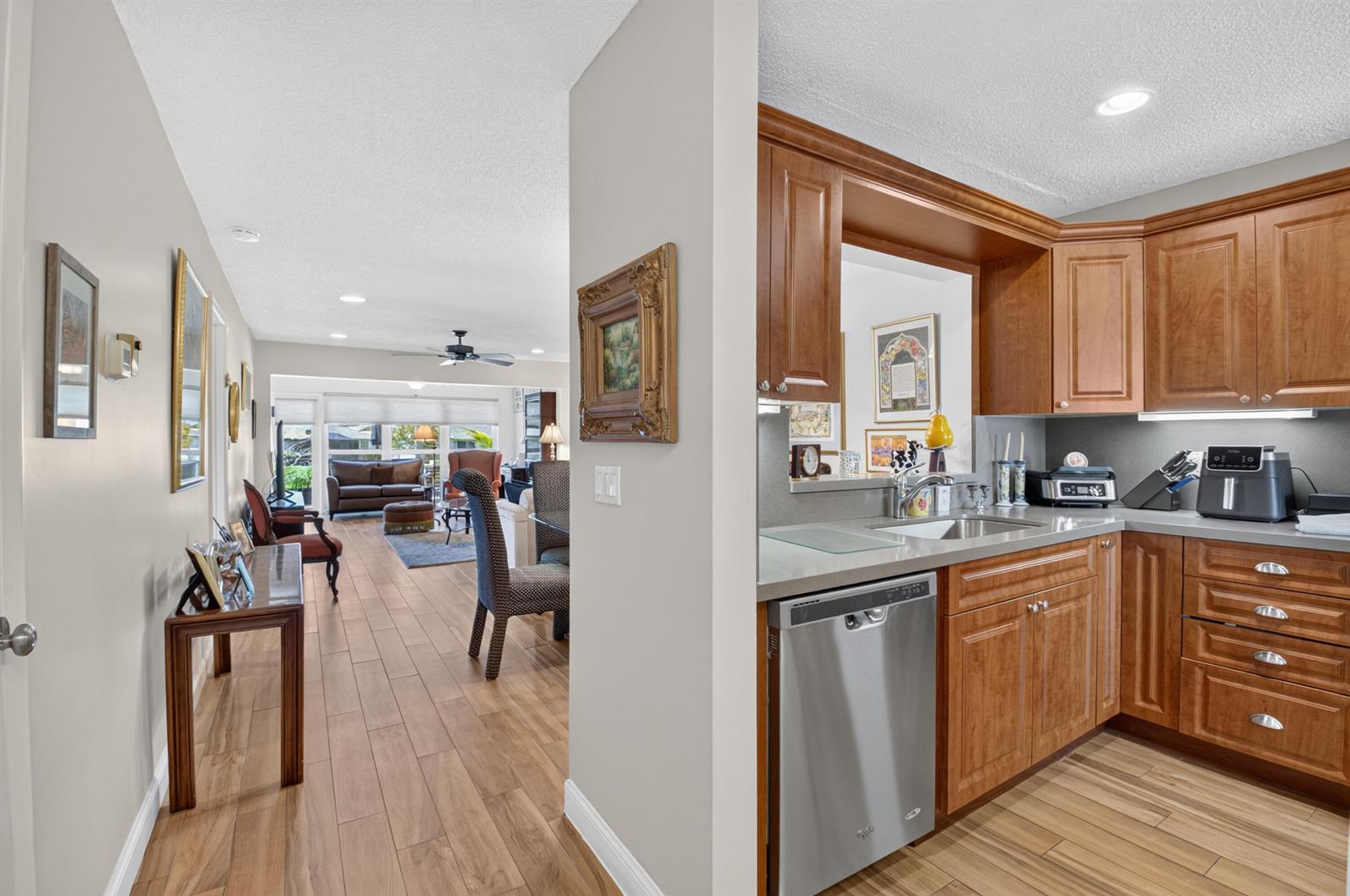 A view from a hallway looking into a living room and an adjacent kitchen — 5896 Via Delray Boulevard # A, Delray Beach FL 33484, DELRAY BEACH, FL