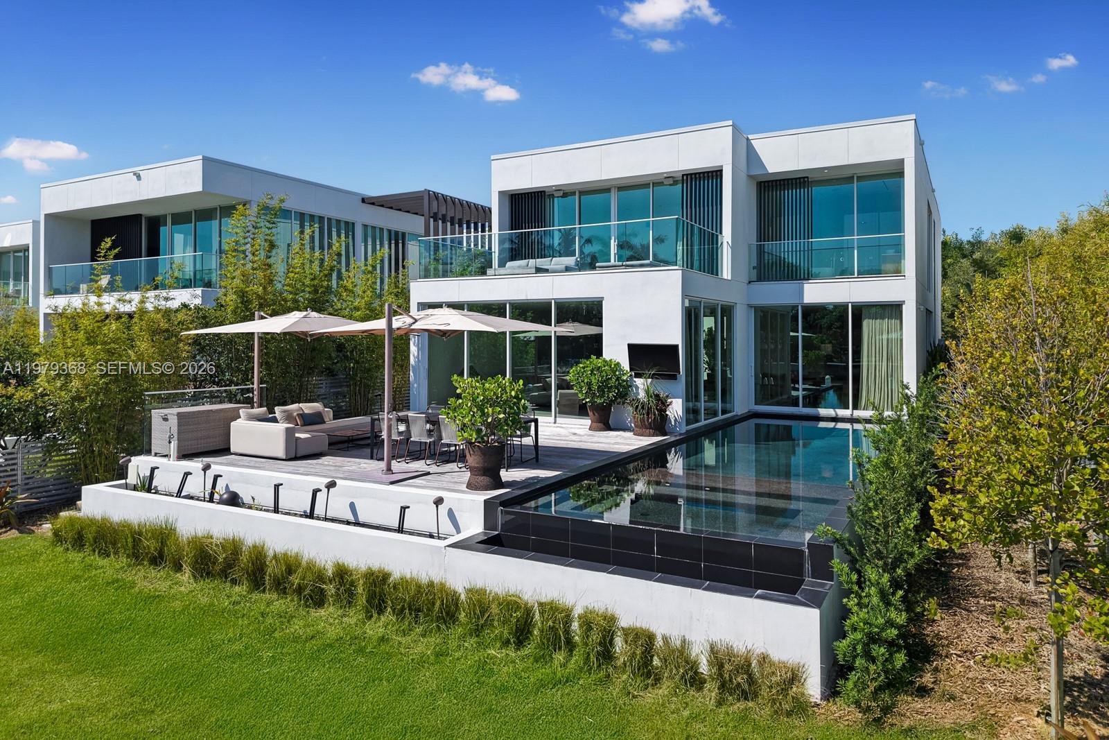 A modern two-story house features a backyard patio, outdoor seating, and an infinity-edge swimming pool — 1051 W 48th St # 4, Miami Beach FL 33140, MIAMI BEACH, FL