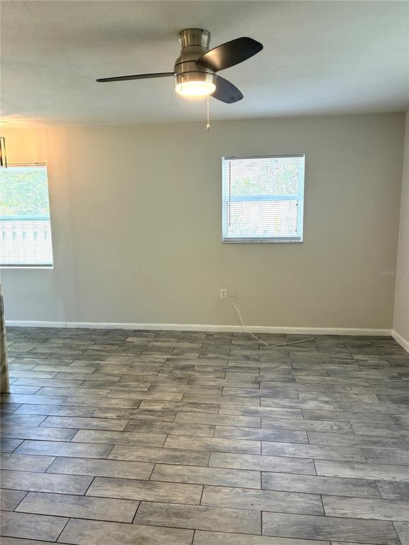 A room with gray wood-look tile flooring, a ceiling fan, and two windows — 618 4TH AVENUE NE, LARGO, FL