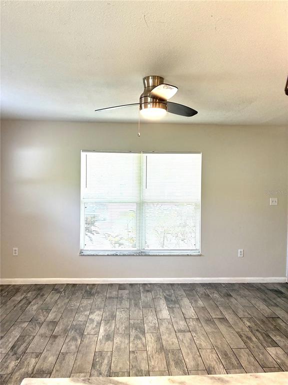 A room with light-colored walls, a ceiling fan, a window with blinds, and wood-look flooring — 618 4TH AVENUE NE, LARGO, FL