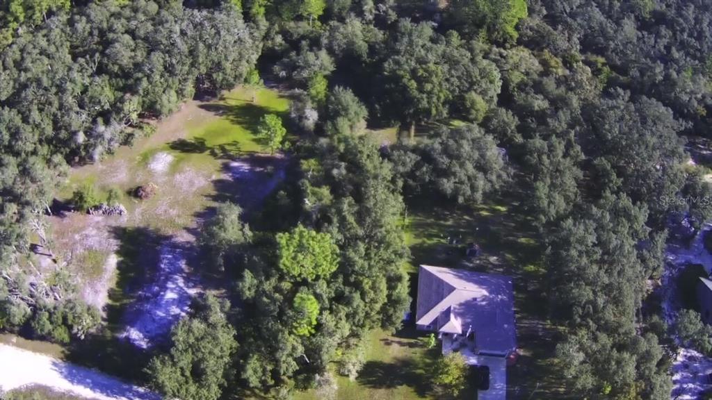 An aerial view shows a house surrounded by dense trees and a large grassy yard — 34429 MANUEL STREET, WEBSTER, FL