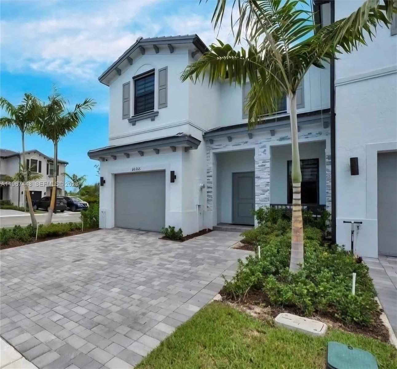 A two-story house exterior with a paved driveway, a garage, and palm trees in front — 20366 NW 4th Path, Miami Gardens FL 33169, MIAMI GARDENS, FL