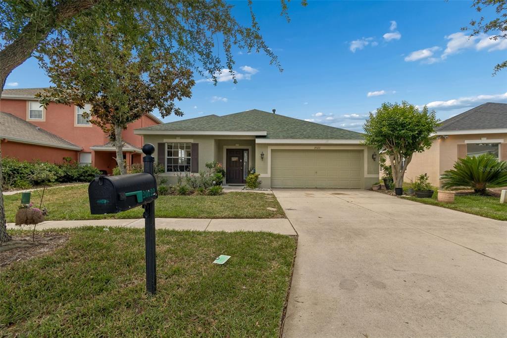 A single-story house with a green roof, tan stucco exterior, and a two-car garage — 20122 NOB OAK AVENUE, TAMPA, FL